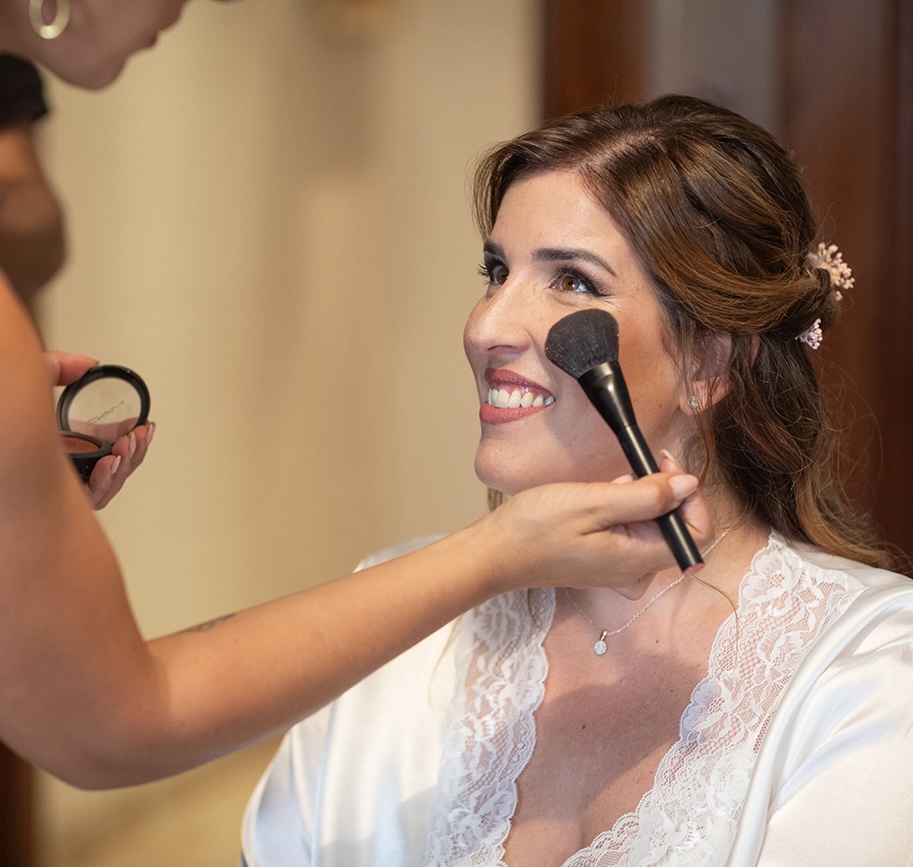 Alba aplicando los últimos retoques de maquillaje a una novia